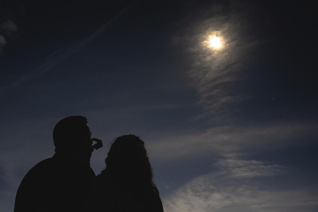 A newlywed couple looks up at the total solar eclipse in Trenton.