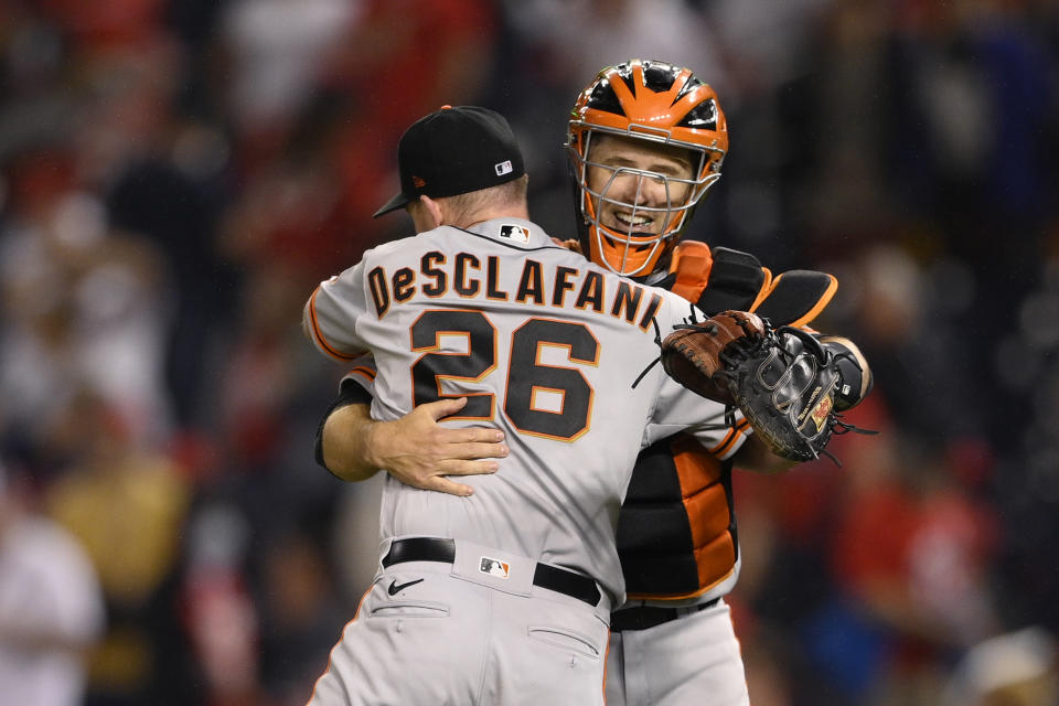 San Francisco Giants starting pitcher Anthony DeSclafani (26) and catcher Buster Posey, right, celebrate after a baseball game against the Washington Nationals, Friday, June 11, 2021, in Washington. DeSclafani threw a two-hitter as the Giants won 1-0. (AP Photo/Nick Wass)