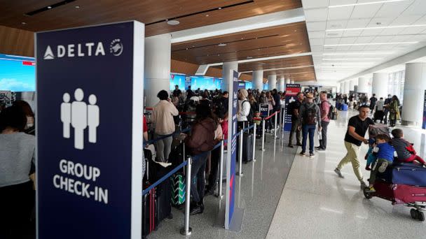 PHOTO: Passengers wait in line at the Delta Air Lines terminal at Los Angeles International Airport, Dec. 25, 2022. (Damian Dovarganes/AP)