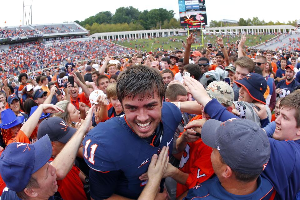 Sep 13, 2014; Charlottesville, VA, USA; Virginia Cavaliers quarterback Greyson Lambert (11) celebrates with fans on the field after the Cavaliers game against the Louisville Cardinals at Scott Stadium. The Cavaliers won 23-21. (Geoff Burke-USA TODAY Sports)