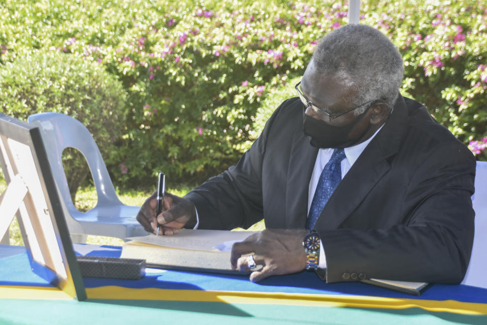 FILE - Solomon Islands Prime Minister, Manasseh Sogavare signs the condolence book at Government House in Honiara, Solomon Islands, during a ceremony to mark the passing of Queen Elizabeth II, Monday, Sept. 12, 2022. Solomon Islands, Papua New Guinea, Samoa and Tuvalu have accepted Australia's help to get representatives to Queen Elizabeth II's funeral and other British Commonwealth island leaders could yet take up the offer, Australia's prime minister, Anthony Albanese said Wednesday, Sept. 14, 2022. (AP Photo/Charley Piringi, File)