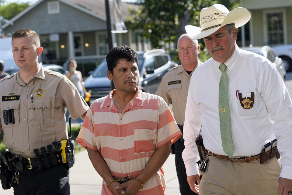 Francisco Oropeza, center, is escorted to the San Jacinto County courthouse by San Jacinto County Sheriff Greg Capers, right, for a hearing Thursday, May 18, 2023, in Coldspring, Texas. Oropeza is suspected of killing five people, including a 9-year-old boy, after neighbors asked him to stop firing off rounds in his yard. (AP Photo/David J. Phillip)