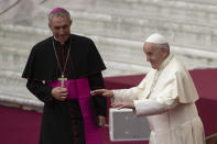 Pope Francis, flanked by Archbishop Georg Gaenswein, applauds in the Paul VI Hall at the Vatican during an audience with members of parish evangelization services, Monday, Nov. 18, 2019. (AP Photo/Alessandra Tarantino)