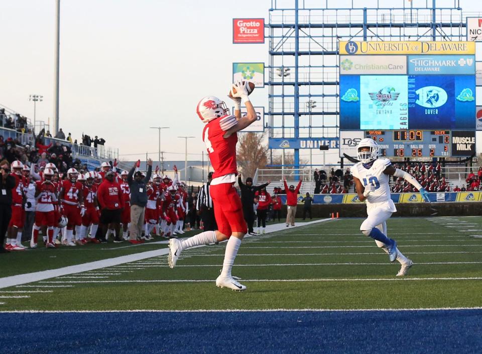 Smyrna's Nolan Fretz (4) pulls in a second quarter 26-yard touchdown reception ahead of Dover's Nehemiah Williams for the first points of the DIAA Class 3A championship at Delaware Stadium, Saturday, Dec 10, 2022.