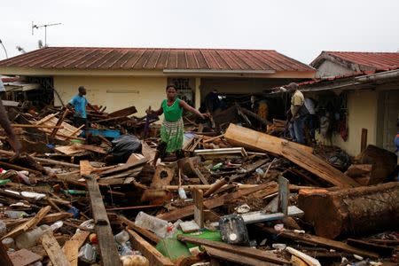 Peoples try to find their belongings between the debris after a flood in Abidjan, Ivory Coast, June 19, 2018. REUTERS/Luc Gnago