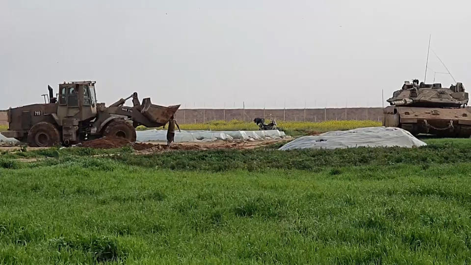 In this frame grab from video, an Israeli military vehicle removes the body of a Palestinian after he was shot and killed by soldiers, along the Gaza-Israel border, Sunday, Feb. 23, 2020. The Israeli military said it shot two Palestinian militants trying to place an explosive device along the border with Gaza, and Palestinian official said one of them was killed. The Hamas militant group accused Israel of abusing the corpse. The incident comes amid a relative lull along the security fence separating Israel from Gaza. (AP Photo)