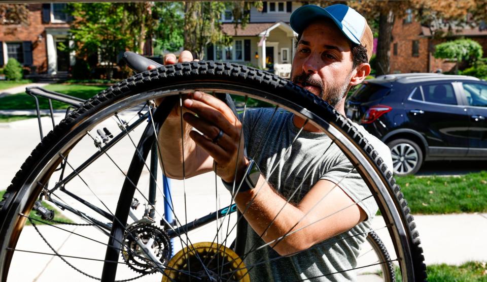 Brian Latulippe, 41 of Royal Oak, works at putting a new tire tube into the rear wheel of a bike as he did repairs. on May 13, 2022.