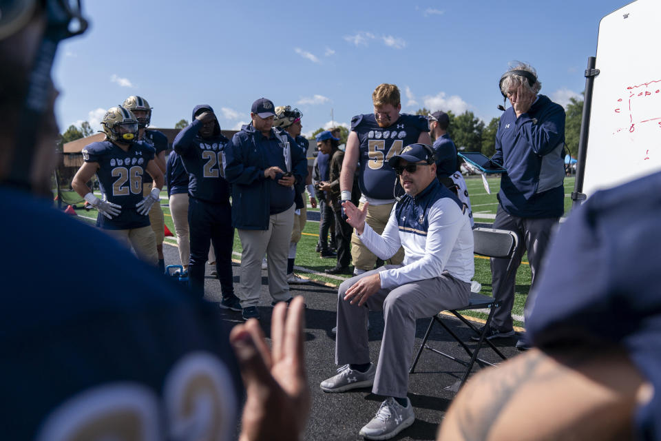 Gallaudet head coach Chuck Goldstein, center, speaks using American Sign Language with players during an NCAA college football game against Hilbert College, Saturday, Oct. 7, 2023, in Washington. (AP Photo/Stephanie Scarbrough)