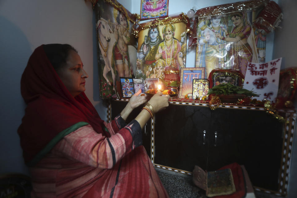 A Hindu woman prays inside their house on the first day of Navratri festival in Jammu, India, Wednesday, March 25, 2020. The world's largest democracy went under the world's biggest lockdown Wednesday, with India's 1.3 billion people ordered to stay home in a bid to stop the coronavirus pandemic from spreading and overwhelming its fragile health care system as it has done elsewhere. For most people, the new coronavirus causes mild or moderate symptoms, such as fever and cough that clear up in two to three weeks. For some, especially older adults and people with existing health problems, it can cause more severe illness, including pneumonia and death. (AP Photo/Channi Anand)