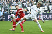 Moenchengladbach's Robin Hack, right, and Berlin's Josip Juranovic, left, challenge for the ball during German Bundesliga soccer match between Borussia Moenchengladbach and 1. FC Union Berlin in Moenchengladbach, Germany, Sunday, April 28, 2024. (Federico Gambarini/dpa via AP)