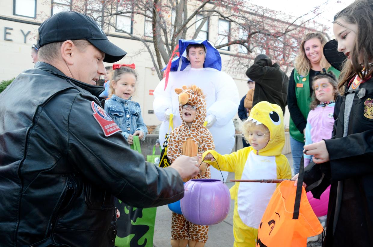 Officer Ben Carlson with the Petoskey Department of Public Safety hands out candy during the downtown Petoskey trick-or-treating on Saturday, Oct. 29, 2022.