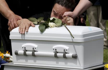 The grandmother of baby Angel Antonio cries on his casket during a burial service at All Saints Cemetery in Des Plaines, Illinois, United States, June 19, 2015. REUTERS/Jim Young