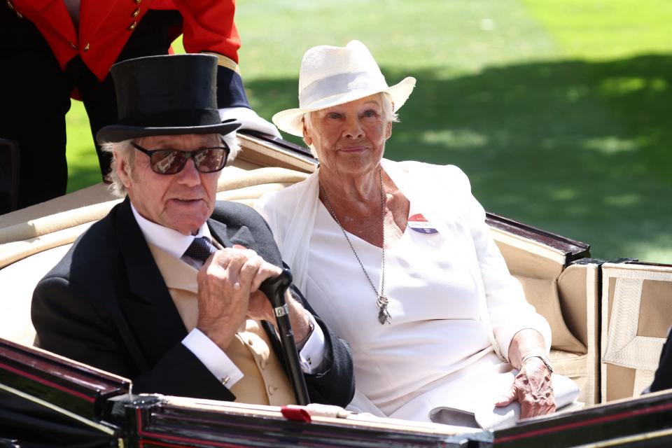 British actress Judi Dench (R) and her partner David Mills (L) arrive in a horse-drawn carriage, part of the Royal Procession on the fourth day of the Royal Ascot horse racing meeting in Ascot, west of London, on June 23, 2023. (Photo by HENRY NICHOLLS / AFP) (Photo by HENRY NICHOLLS/AFP via Getty Images)