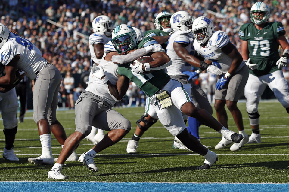 Tulane running back Shaadie Clayton (0) breaks free from Memphis linebacker Geoffrey Cantin-Arku (9) to score a touchdown during the first half of an NCAA college football game in New Orleans, Saturday, Oct. 22, 2022. (AP Photo/Tyler Kaufman)