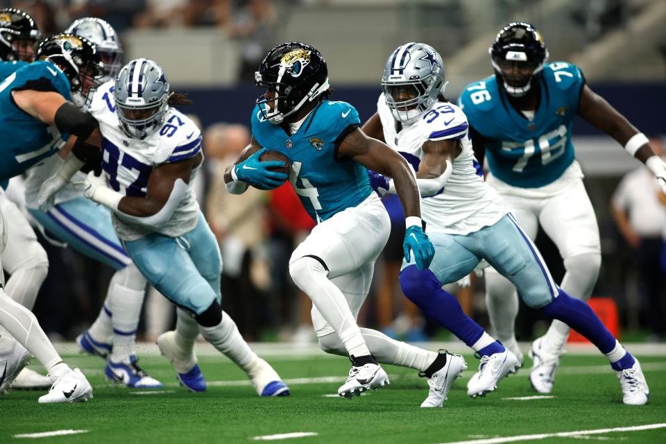 Aug 12, 2023; Arlington, Texas, USA; Jacksonville Jaguars running back Tank Bigsby (4) runs the ball against Dallas Cowboys linebacker Damone Clark (33) in the first quarter at AT&T Stadium. Mandatory Credit: Tim Heitman-USA TODAY Sports