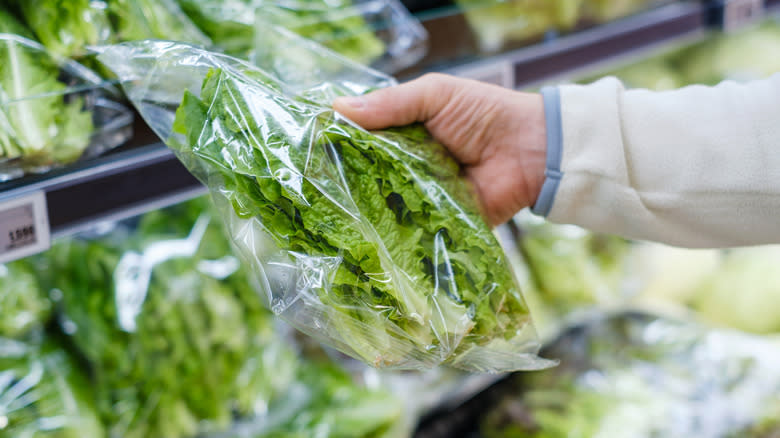 man holding lettuce in grocery store