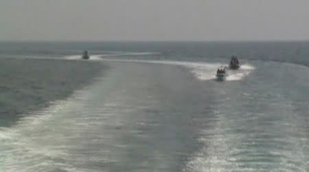 Small Iranian military motorboats ride in the wake of U.S. Coast Guard cutter Adak in the Strait of Hormuz in this still image taken from January 6, 2012 video footage. REUTERS/U.S. Department of Defense/Handout