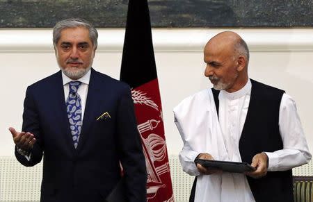 Afghan rival presidential candidates Abdullah Abdullah (L) and Ashraf Ghani stand together after exchanging signed agreements for the country's unity government in Kabul September 21, 2014. REUTERS/Omar Sobhani