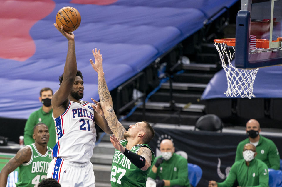 Philadelphia 76ers center Joel Embiid, left, shoots over Boston Celtics center Daniel Theis during the first half of an NBA basketball game Wednesday, Jan. 20, 2021, in Philadelphia. (AP Photo/Chris Szagola)