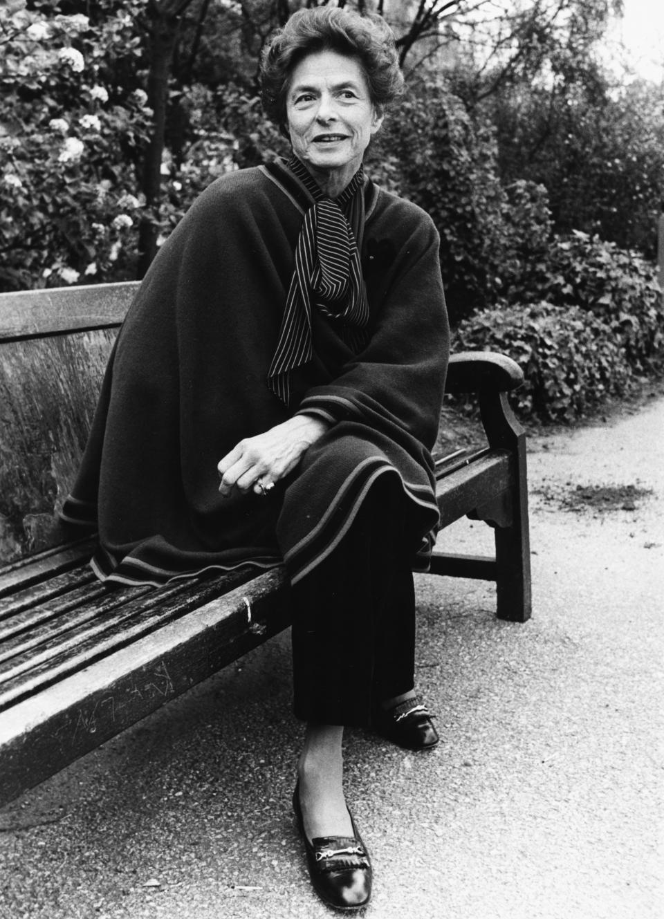 Portrait of actress Ingrid Bergman sitting on a park bench in London.