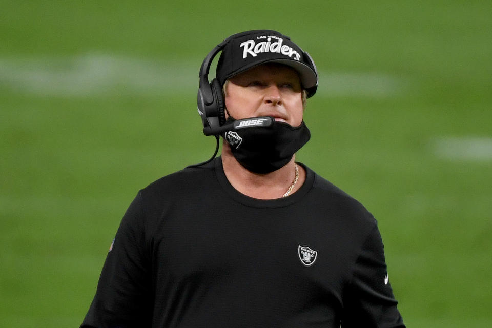 Jon Gruden wears a protective face mask incorrectly with it covering his chin and not his nose and mouth. 