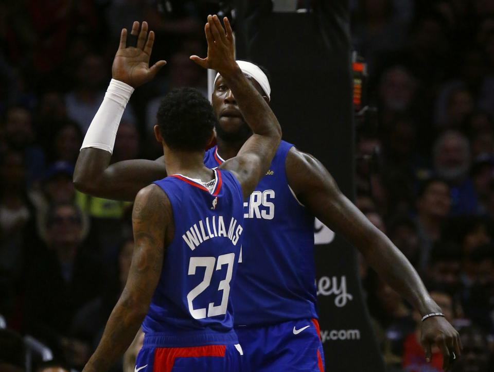 Clippers forward Montrezl Harrell is congratulated by teammate Lou Williams after scoring a basket.