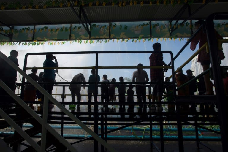 Revellers on stages spray passersby with water hoses during Thingyan celebrations in Yangon