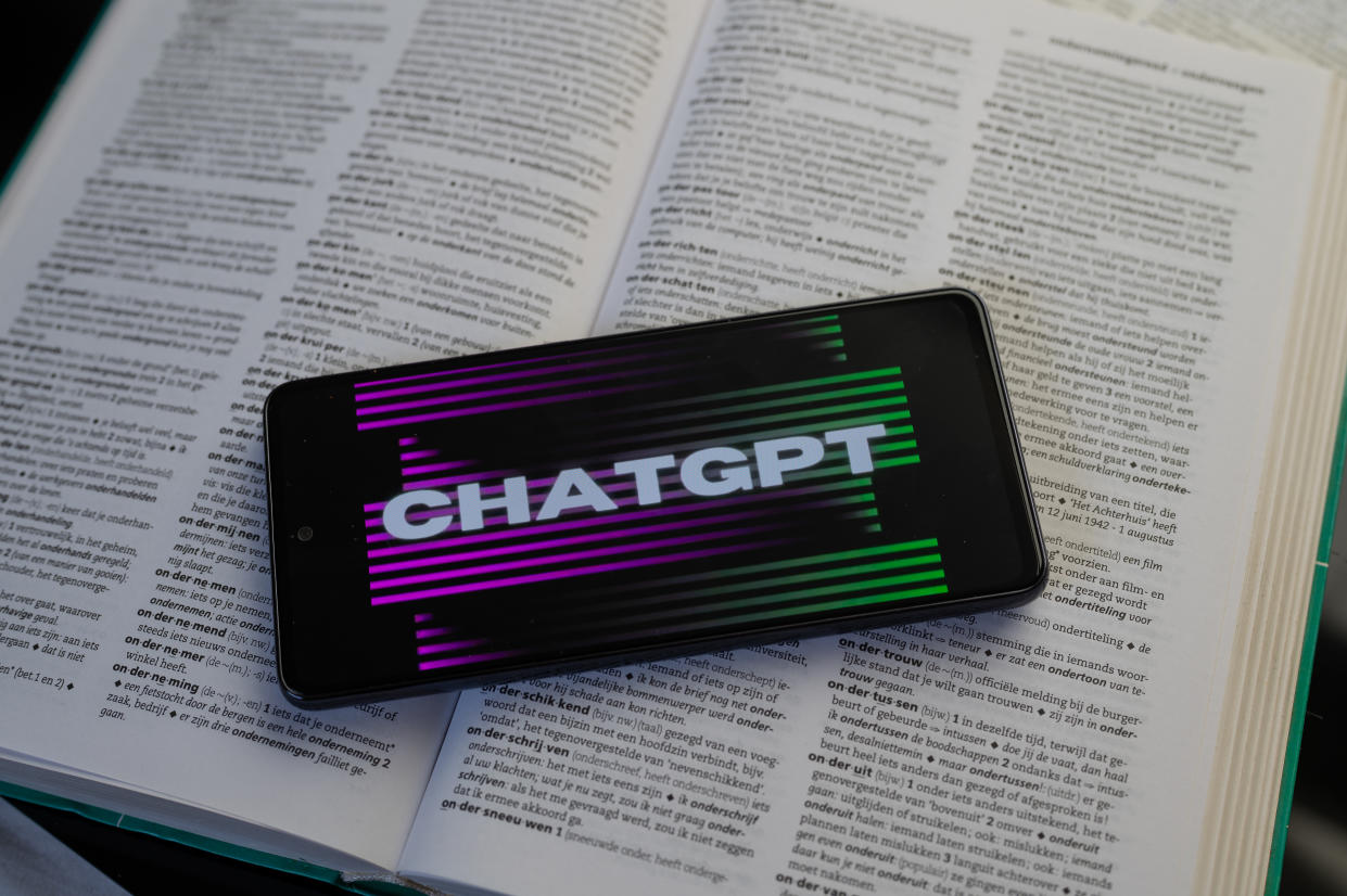 ChatGPT displayed on a smart phone with a dictionary book, seen in this photo illustration. On 20August 2023 in Brussels, Belgium. (Photo by Jonathan Raa/NurPhoto via Getty Images)