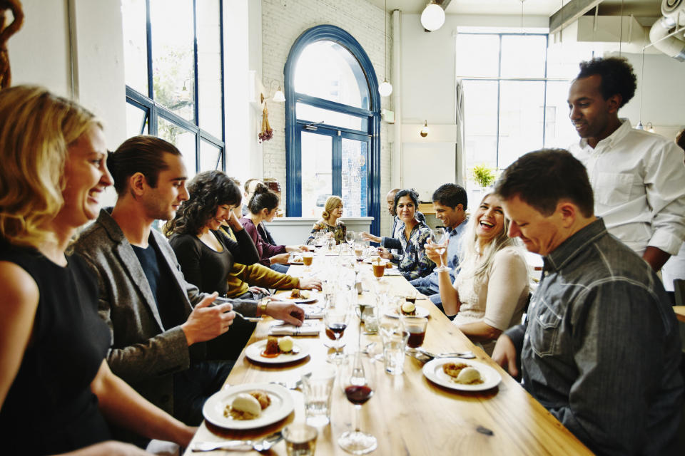 People gathered at a table in a restaurant.