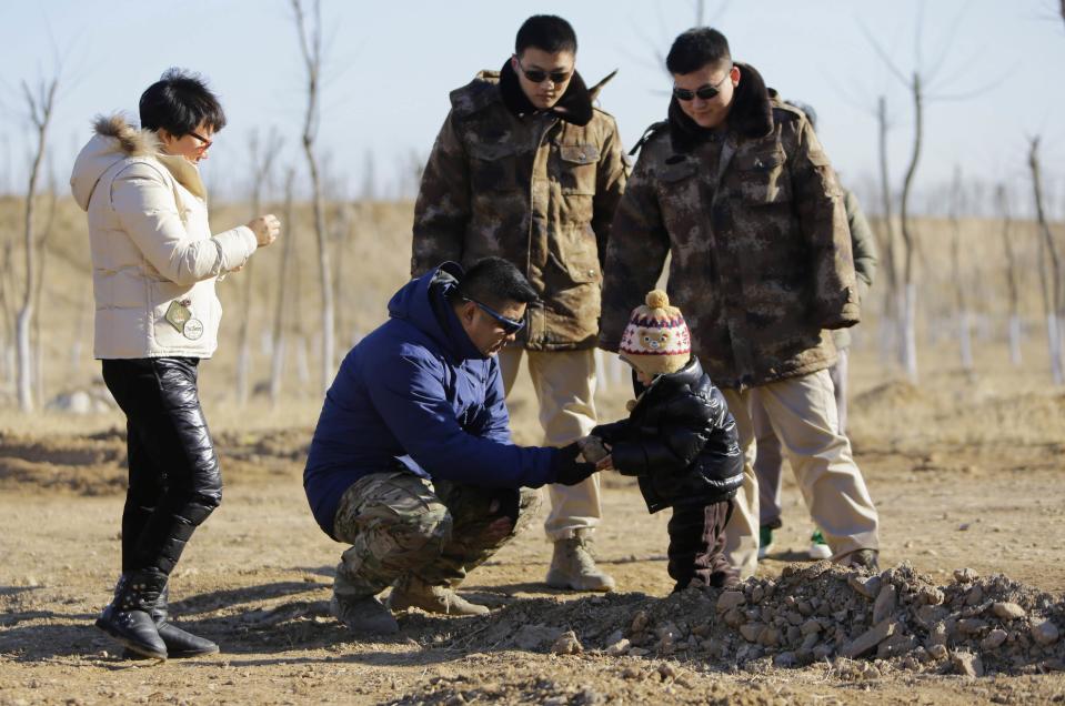 Bodyguards Han and Wang, who were hired from Tianjiao Special Guard/Security Consultant, watch their employer Zhang and his wife play with their three-year-old son as they guard the family on the outskirts of Beijing