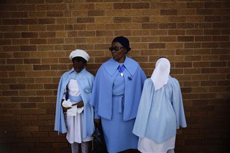 A woman and two girls from the Children of Mary Sodality wait before a service for former South African President Nelson Mandela, in the Regina Mundi Church in Soweto December 8, 2013. REUTERS/Kevin Coombs