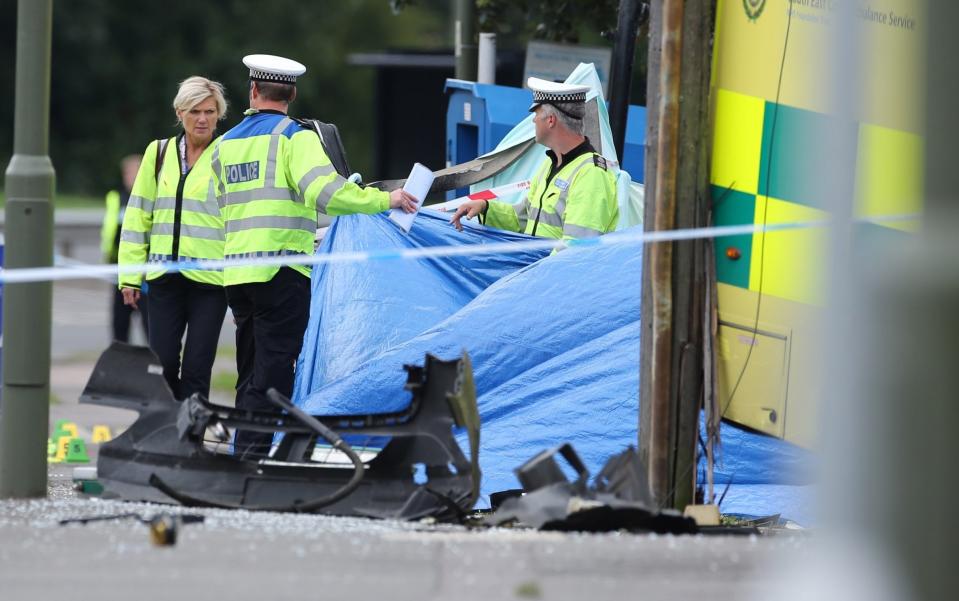 Police officers at the scene of the fatal collision between an ambulance and pedestrian - EDDIE MITCHELL