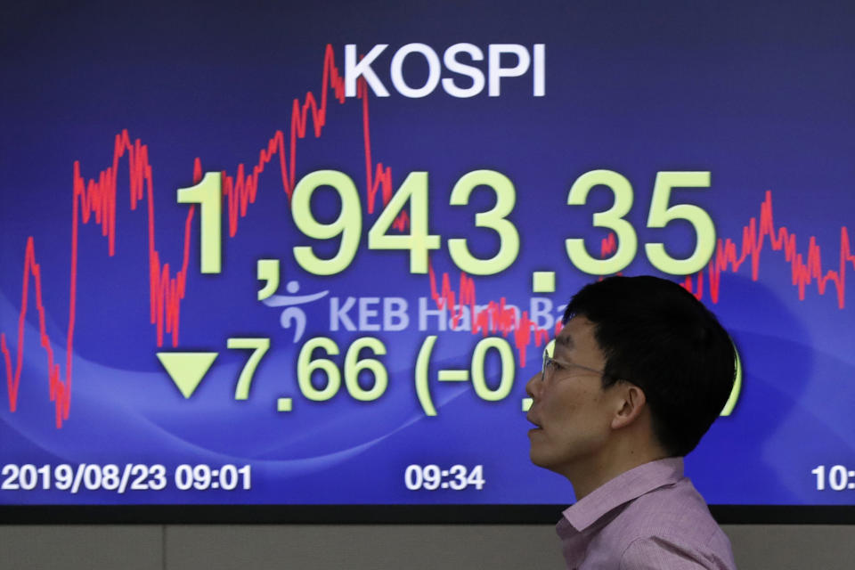 A currency trader walks by the screen showing the Korea Composite Stock Price Index (KOSPI) at the foreign exchange dealing room in Seoul, South Korea, Friday, Aug. 23, 2019. Asian stock markets were mixed on Friday after Wall Street declined ahead of a closely watched speech by the U.S. Federal Reserve chairman. (AP Photo/Lee Jin-man)
