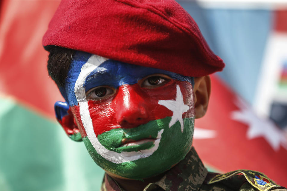 A child, his face covered with the colours of the flag of Azerbaijan participates in a protest supporting Azerbaijan, in Istanbul, Sunday, Oct. 4, 2020. Armenian and Azerbaijani forces continue their fighting over the separatist region of Nagorno-Karabakh, following the reigniting of a decades-old conflict. Turkey, which strongly backs Azerbaijan, has condemned an attack on Azerbaijan's second largest city Gence and said the attack was proof of Armenia's disregard for law. (AP Photo/Emrah Gurel)