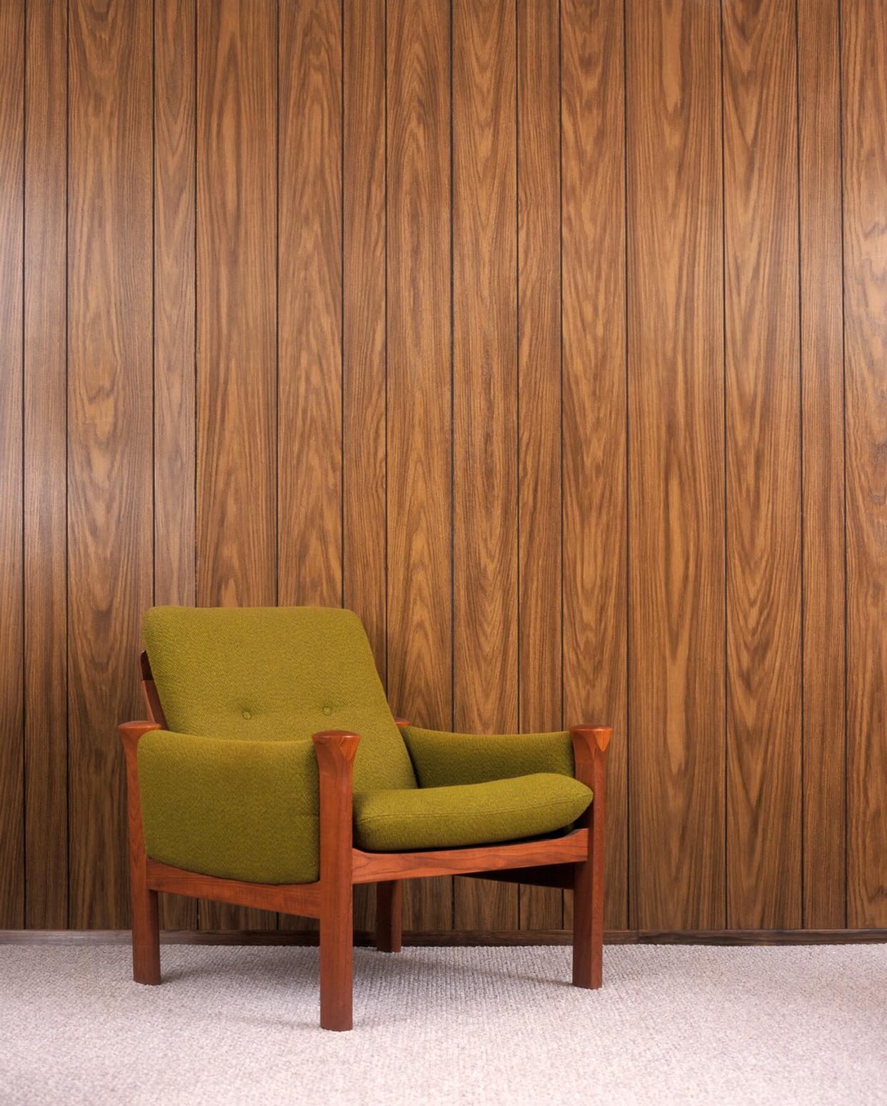 Chair in front of wood paneling