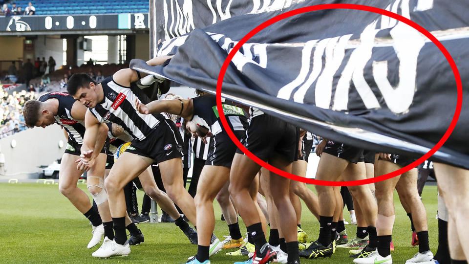 Seen here, Collingwood players run through their banner before the Port Adelaide game.