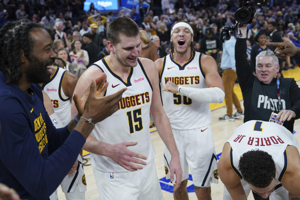 Denver Nuggets center Nikola Jokic (15) celebrates with teammates after his 3-pointer against the Golden State Warriors at the end of an NBA basketball game Thursday, Jan. 4, 2024, in San Francisco. (AP Photo/Loren Elliott)