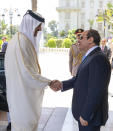 In this photo made available by Qatar News Agency, QNA, Qatari Emir Tamim bin Hamad Al Thani, left, shakes hands with Egyptian President Abdel-Fattah el-Sissi, at the presidential palace in Cairo, Egypt, Saturday, June 25, 2022. Qatar's emir arrived in Cairo to hold talks with Egypt's president in his first visit since the two countries agreed to reset relations after more than seven years of diplomatic animosity. (QNA via AP)