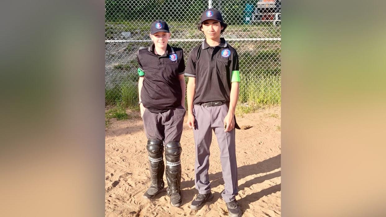 Baseball umpires Rowan Brown, left, and Tyler Suzuki, right, are shown wearing the green arm bands at a game this week in the Halifax area. (Submitted by Chad Falconer - image credit)