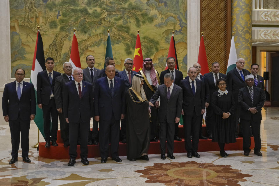 Chinese Foreign Minister Wang Yi, foreground center, shakes hands with Saudi Arabia's Foreign Minister Faisal bin Farhan Al Saud during a group photo session with his counterparts from left, Palestine Foreign Minister Riyad al-Maliki, Egyptian Foreign Minister Sameh Shoukry, Jordanian Deputy Prime Minister and Foreign Minister Ayman Safadi, Indonesian Foreign Minister Retno Marsudi, Secretary-General of the Organization of Islamic Cooperation (OIC) Hissein Brahim Taha and their delegations prior to their meeting at the Diaoyutai state guesthouse in Beijing, Monday, Nov. 20, 2023. China's foreign minister welcomed five Arab and Islamic counterparts to Beijing on Monday, saying his country would work with "our brothers and sisters" in the Arab and Islamic world to try to end the fighting in Gaza as soon as possible. (AP Photo/Andy Wong)