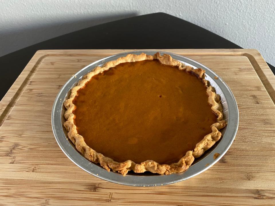 baked pumpkin pie on a kitchen cutting board