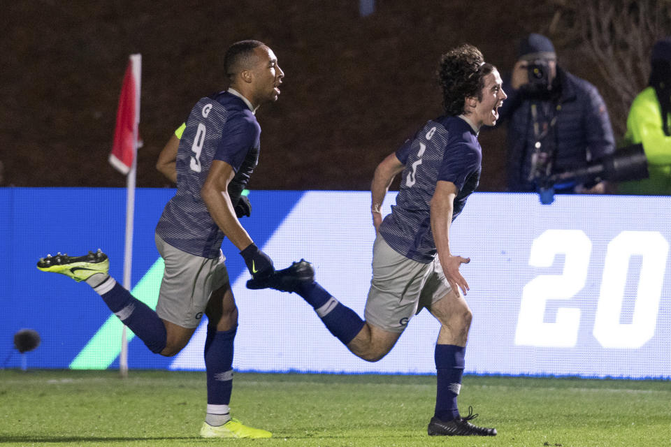 Georgetown's Paul Rothrock (3) celebrates with Derek Dodson (9) after scoring a goal during the first half of the NCAA college soccer championship against Virginia in Cary, N.C., Sunday, Dec. 15, 2019. (AP Photo/Ben McKeown)