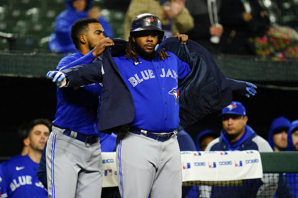 Toronto Blue Jays' Vladimir Guerrero Jr., right, celebrates near the dugout with Teoscar Hernandez after hitting a solo home run against the Baltimore Orioles during the third inning of a baseball game, Monday, Oct. 3, 2022, in Baltimore. (AP Photo/Julio Cortez)