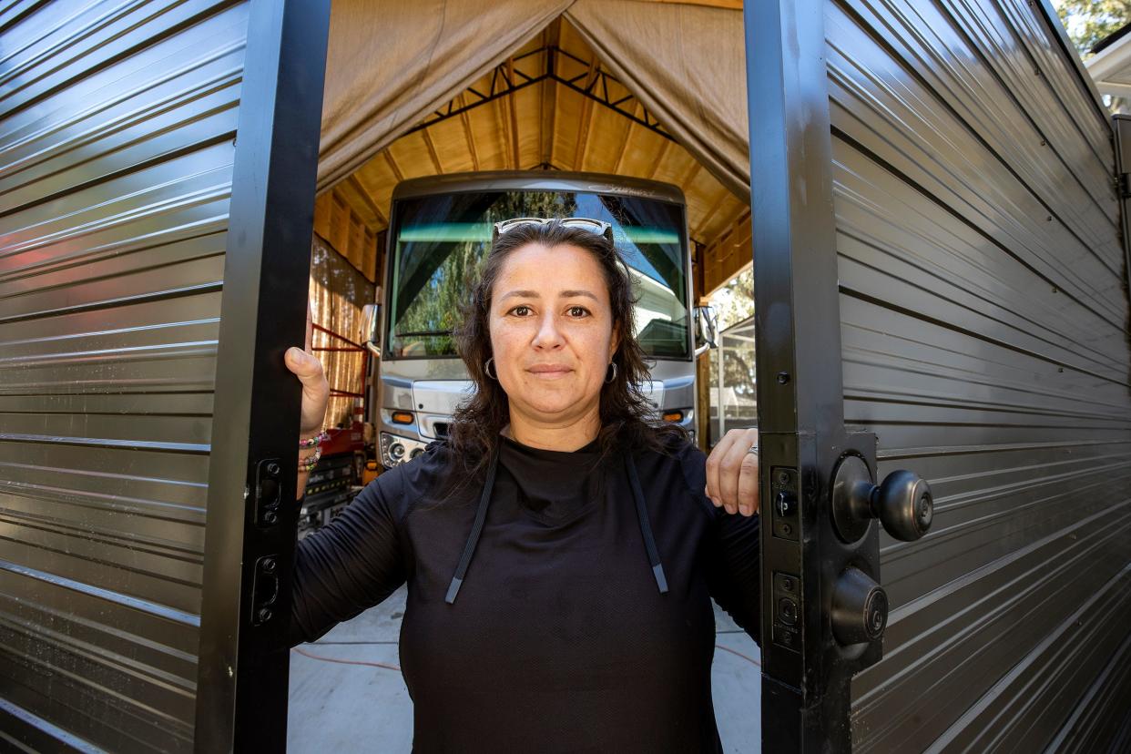 Alyne Aca stands at the front of the enclosure for a motorcoach at her home in the Longwood Oaks neighborhood in South Lakeland. The homeowners association's board of directors has sued Aca and her husband, first seeking to block the construction and now seeking to have the carport removed. Board members claim she didn't have the proper permission before having the enclosure built.