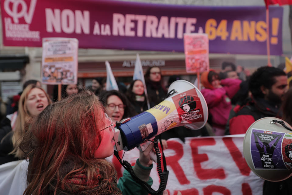 A young protestor uses a megaphone during a demonstration against pension changes, Thursday, Jan. 19, 2023 in Paris. Workers in many French cities took to the streets Thursday to reject proposed pension changes that would push back the retirement age, amid a day of nationwide strikes and protests seen as a major test for Emmanuel Macron and his presidency. (AP Photo/Lewis Joly)