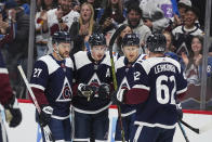 Colorado Avalanche center Nathan MacKinnon (29) celebrates with teammates after scoring a goal in the second period of an NHL hockey game against the Minnesota Wild Tuesday, April 9, 2024, in Denver. (AP Photo/Bart Young)