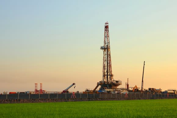 An onshore drilling rig in a green field.