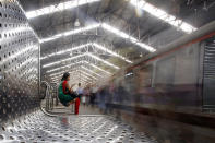 A woman checks her mobile phone at a train station in Mumbai, India.