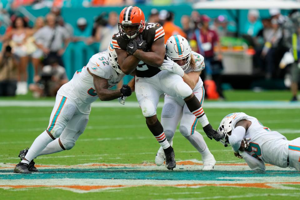 Browns running back Nick Chubb is tackled by Dolphins defenders Jeff Wilson Jr. (23), Elandon Roberts (52) and Jerome Baker (55) during the second half, Sunday, Nov. 13, 2022, in Miami Gardens, Fla.