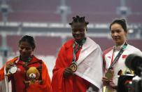 Athletics - 2018 Asian Games - Women's 100m Final - GBK Main Stadium – Jakarta, Indonesia – August 26, 2018 – Gold medallist Edidiong Odiong of Bahrain, silver medallist Dutee Chand of India and bronze medallist Wei Yongli of China pose during the medal ceremony. REUTERS/Darren Whiteside